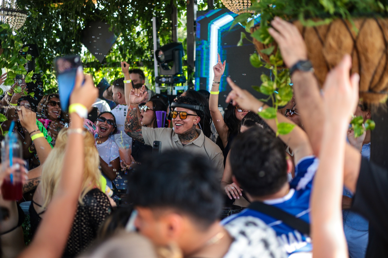 DAVINCII on the decks mid-crowd, pointing as the crowd roars