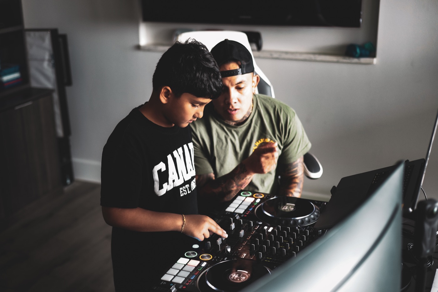 Vince guiding his nine-year-old student's hand across the mixer faders